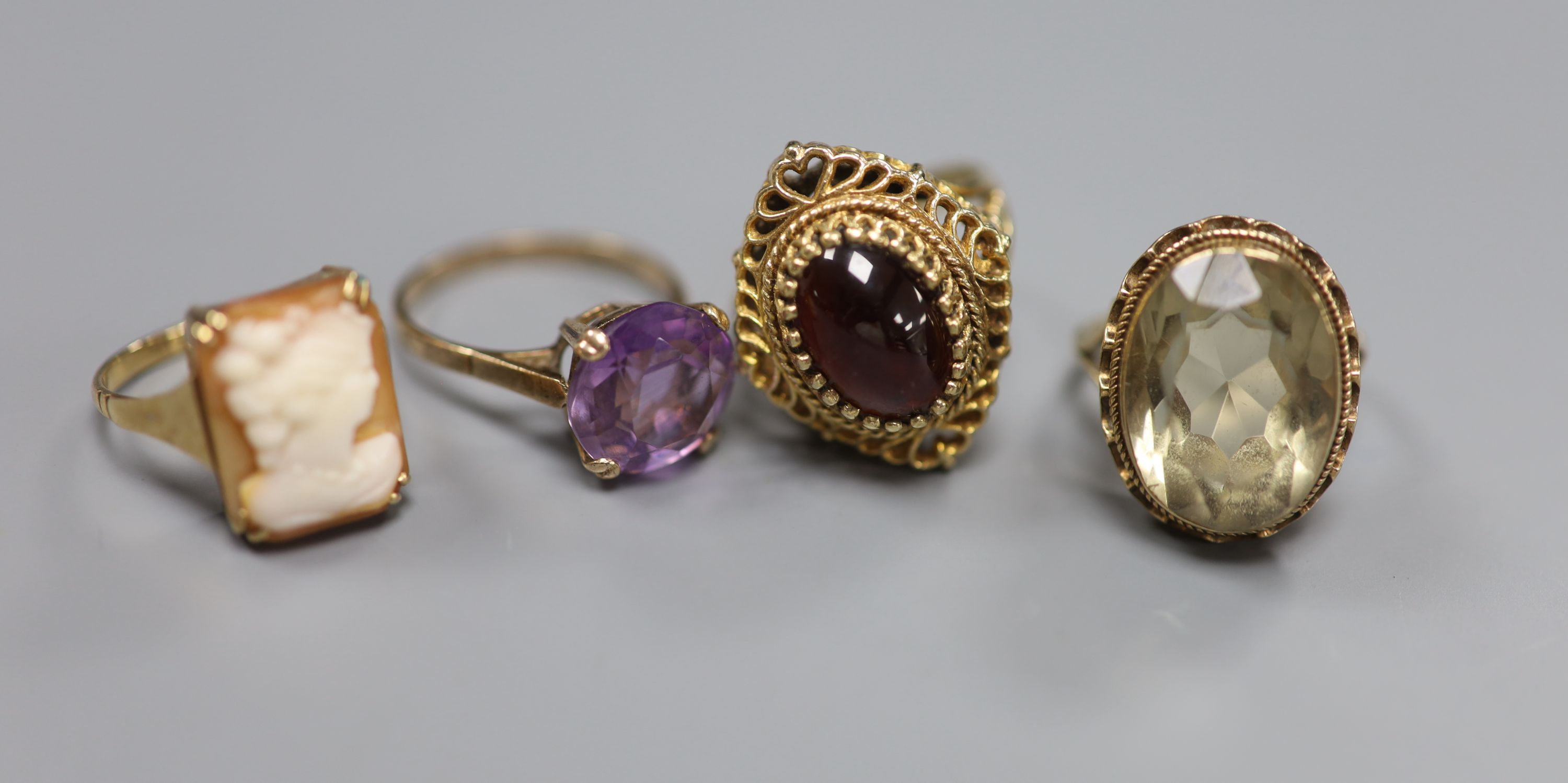 A Renaissance style cabochon garnet ring, 9ct gold stepped pierced setting, 7.2g and three other 9ct dress rings,